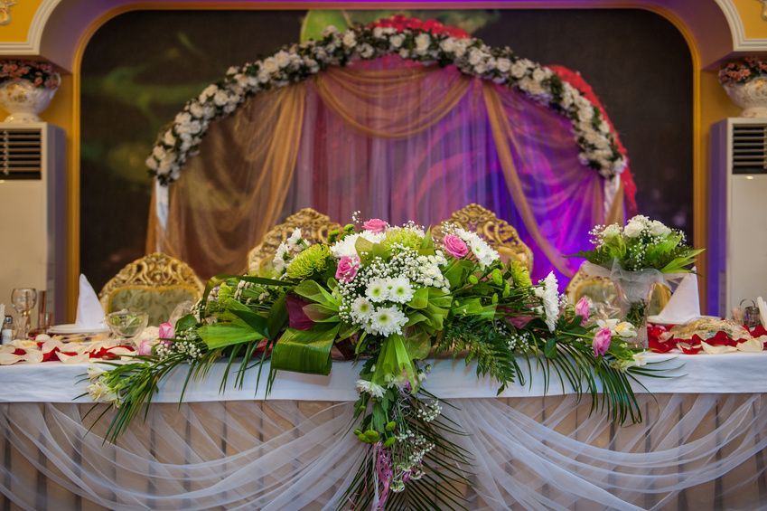 Декор стола жениха и невесты из живых цветов.