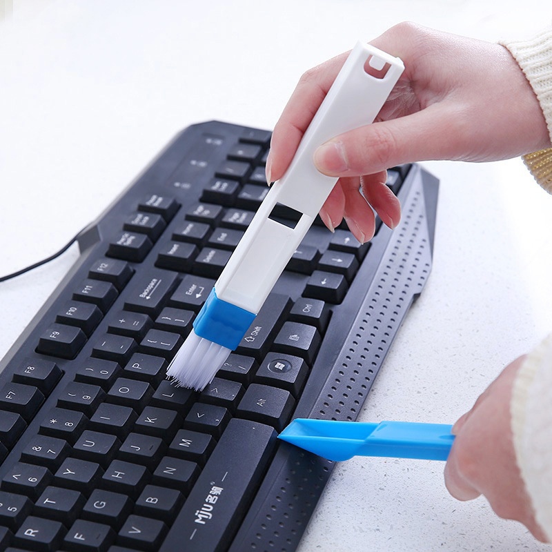 Чистка клавиатуры при помощи специальной щёточки.