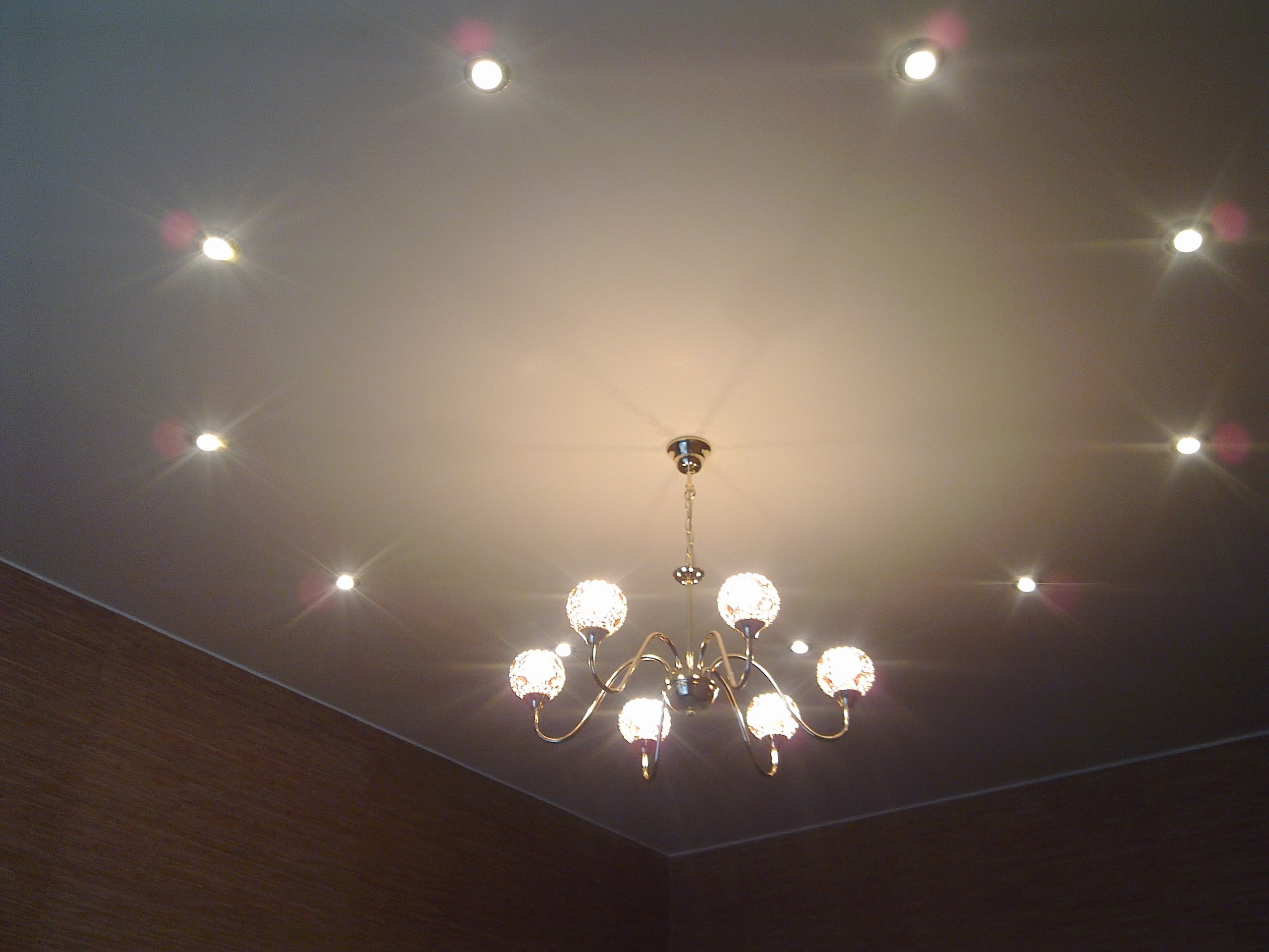 Точечные светильники и люста на натяжном потолке.